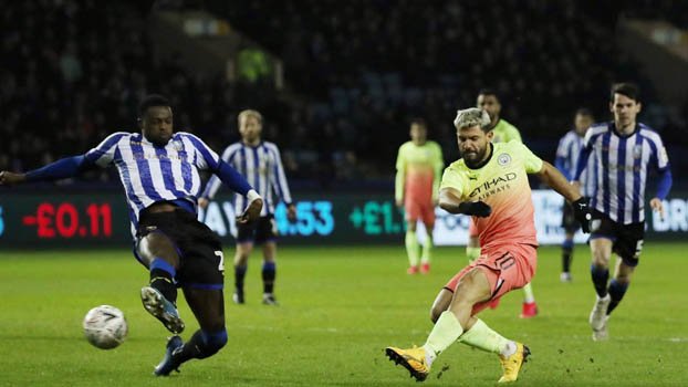 Aguero sends Man City through